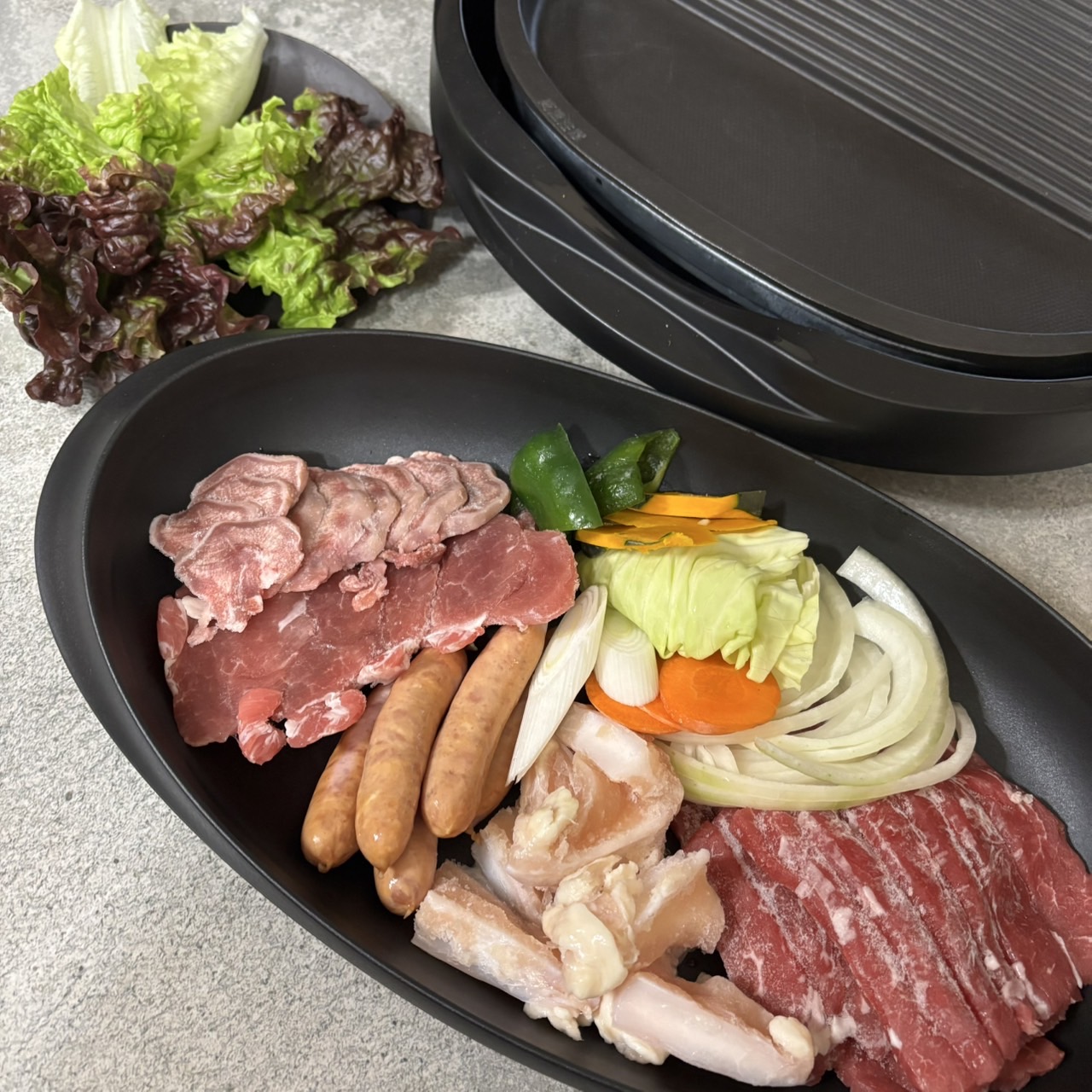 ホットプレート横にARASの黒い皿を並べたBBQシーン