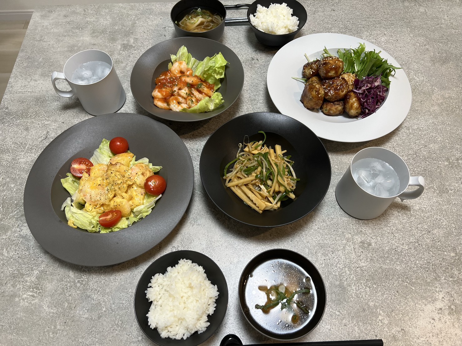 ARAS(エイラス)の黒いボウルと皿に主菜・サラダ・スープを盛った食卓