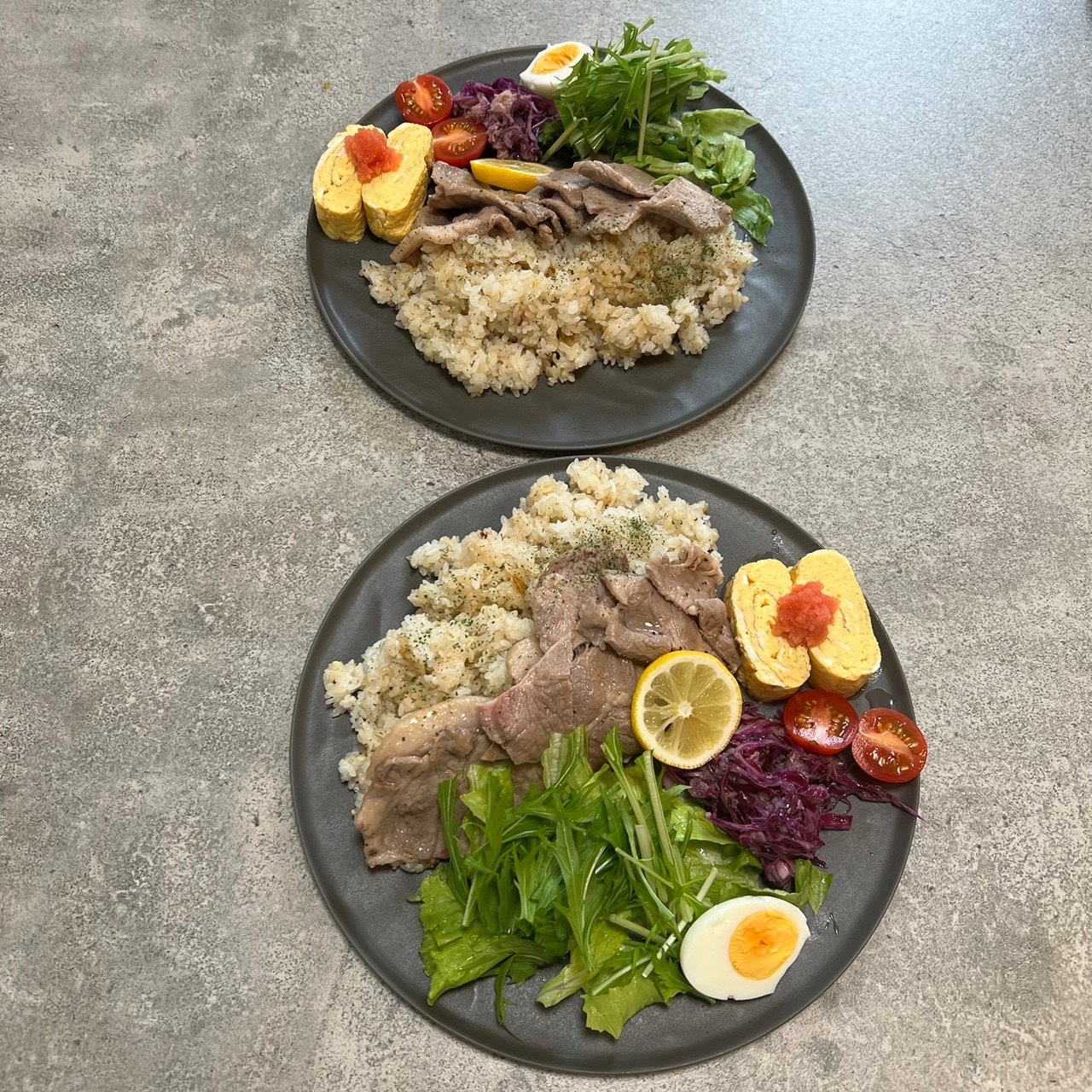 黒いARASの大皿に冷しゃぶサラダ風の料理を盛った食卓