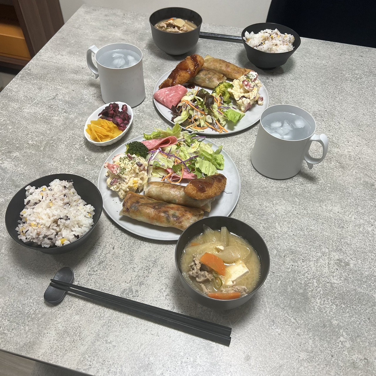 ARASの黒い器で主菜・サラダ・ご飯・味噌汁を並べた定食スタイルとマグカップ