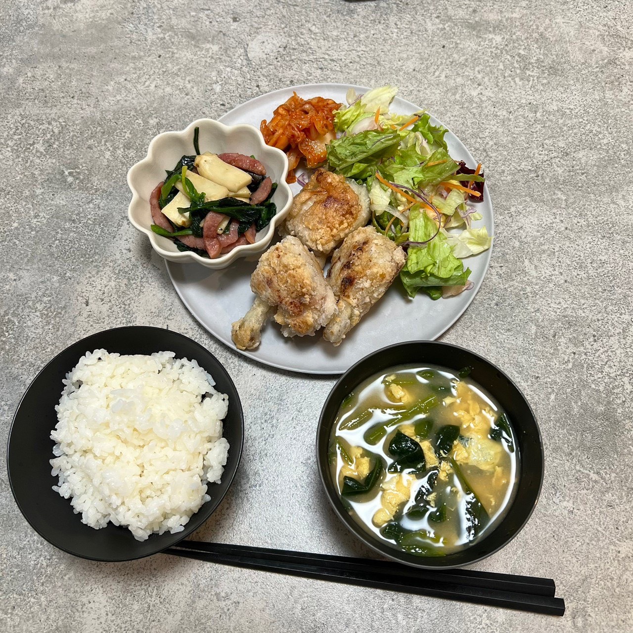 黒いARAS食器にサラダ・主菜・ご飯・スープを並べた定食