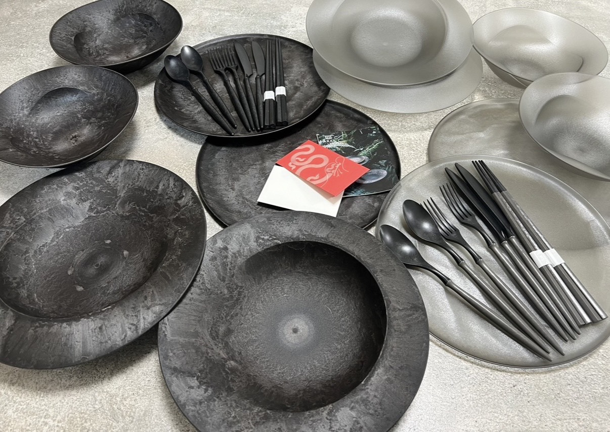 ARASの黒い食器とカトラリーを一面に並べた商品フラットレイ